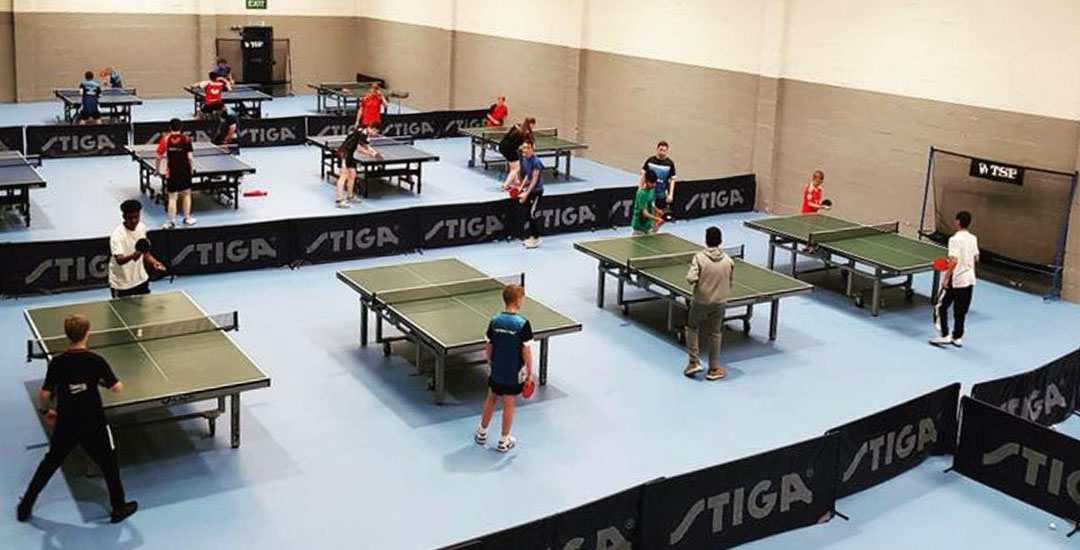 A hall full of table tennis tables and players