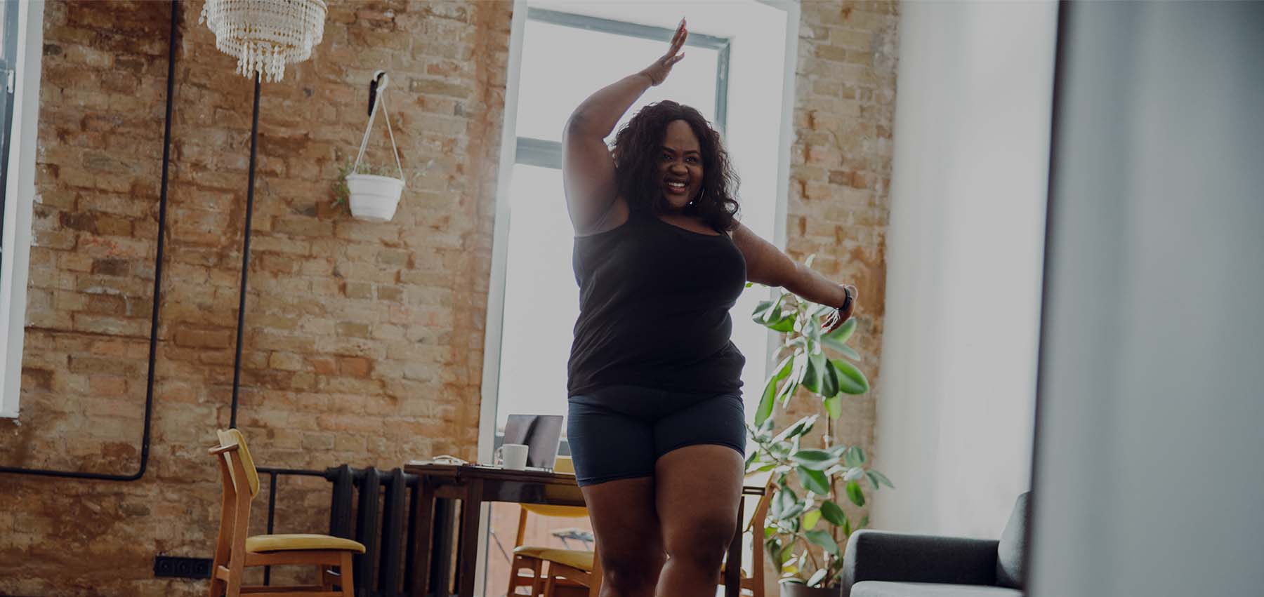 A large black lady dances in her living room