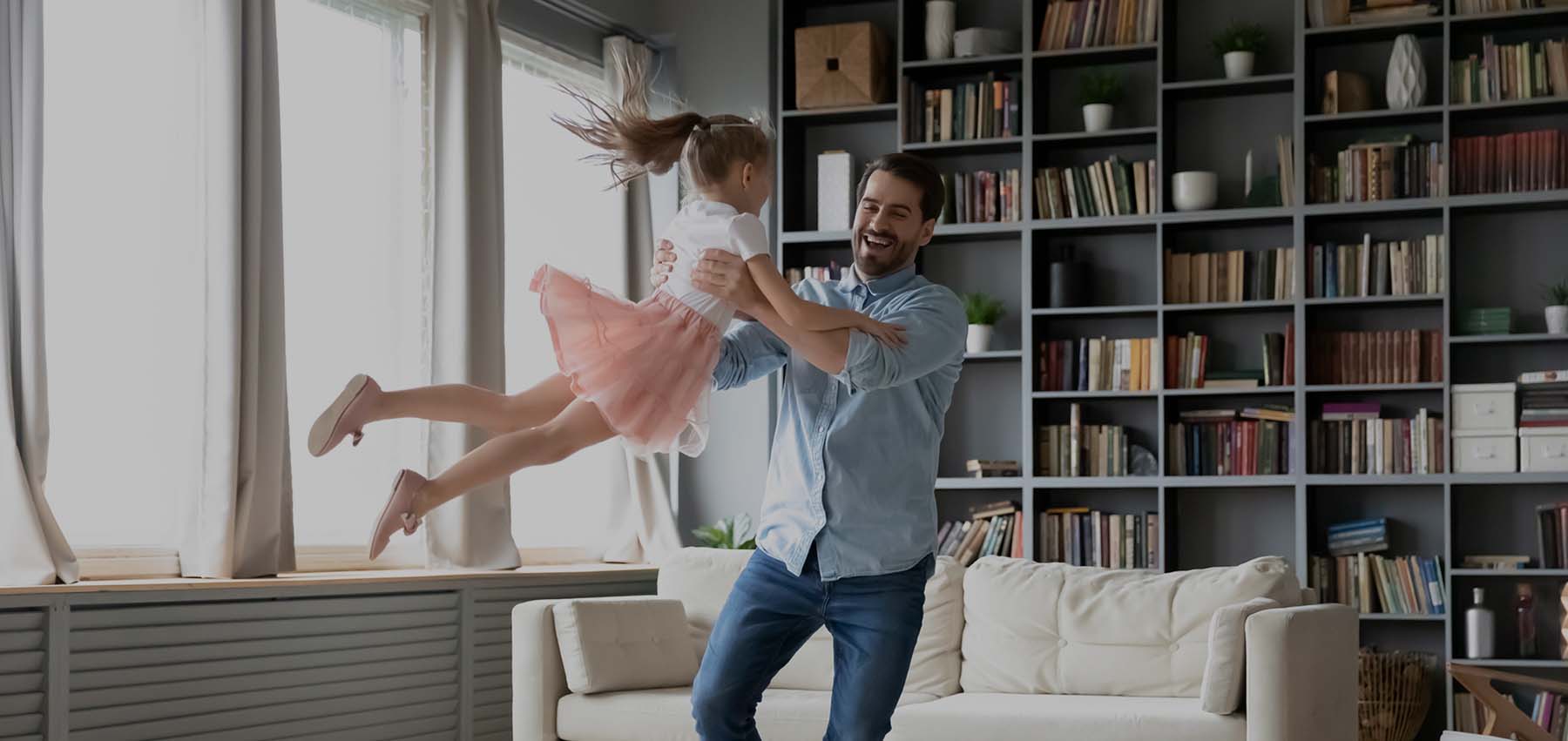 A father swings his daughter around in the lounge